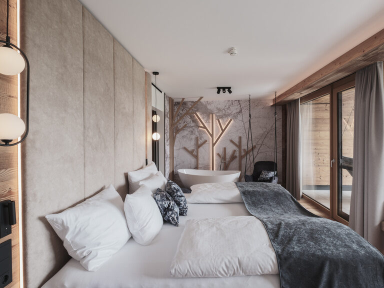 Gemütliches Schlafzimmer des Tonihofs mit komfortablem Bett und weitem Fenster, das einen herrlichen Ausblick bietet.